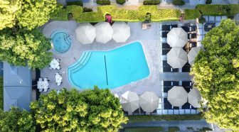Overhead view of pool surrounded by umbrellas and trees