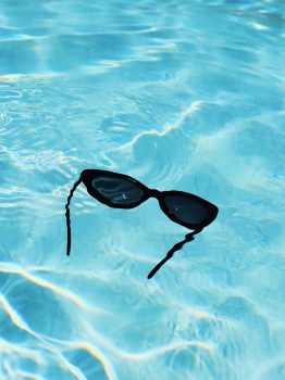 black sunglasses floating in pool